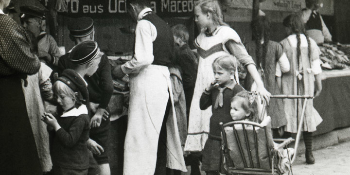 Kinder an einem Marktstand um 1900